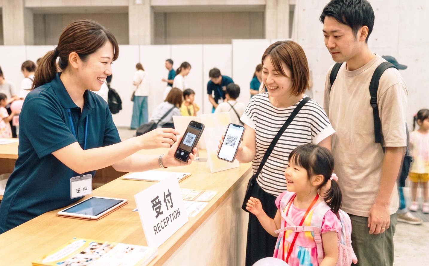 受付でQRコードを読み取る家族
