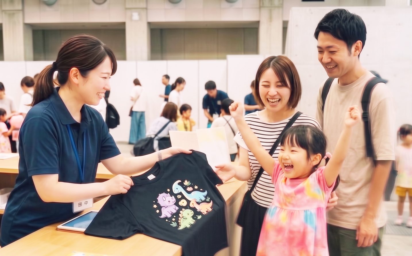 景品の恐竜Tシャツを受け取って喜ぶ女の子