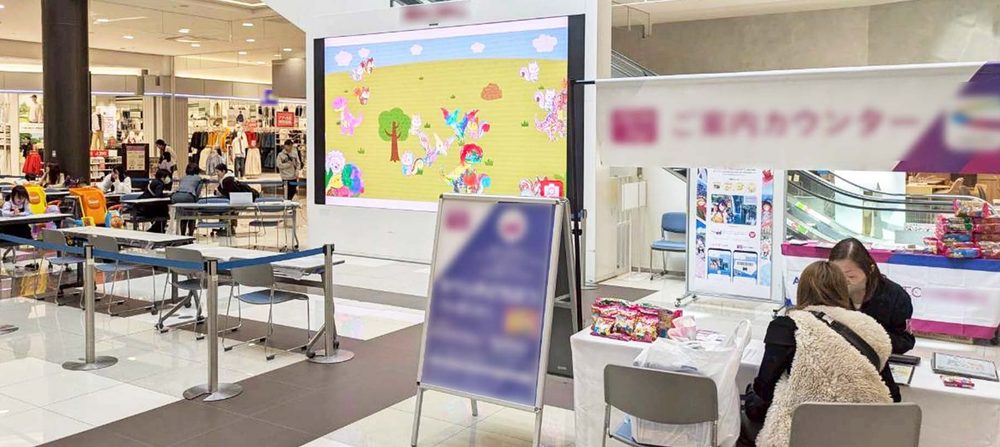 商業施設の大型モニターとイベント受付