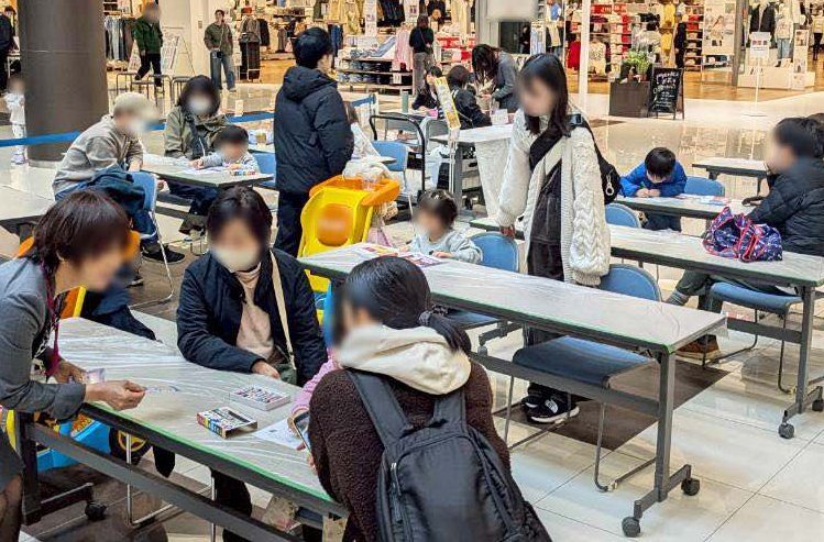 テーブルでぬりえを楽しむ家族連れ